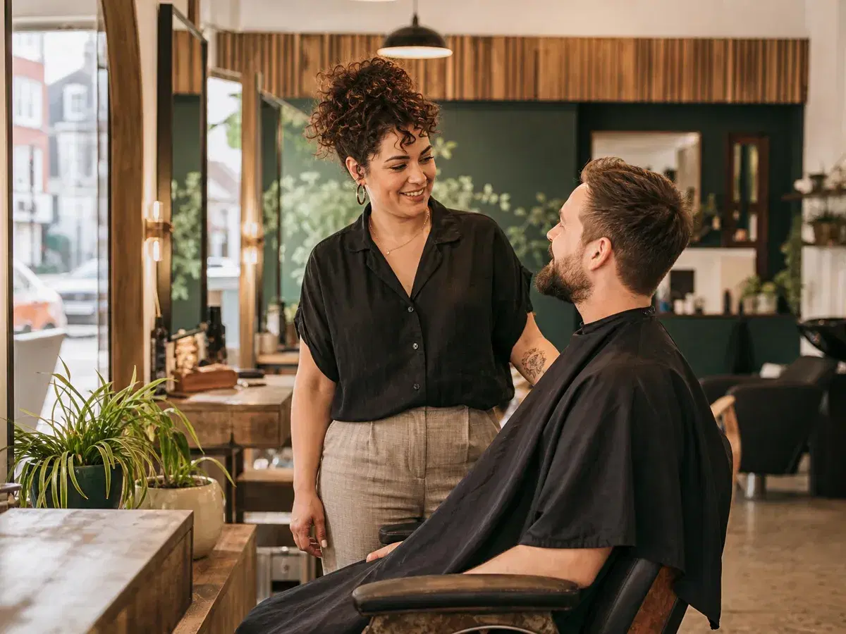 A stylist welcoming a client in an independent hair and barber salon